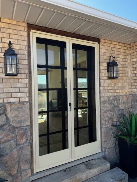 Screen doors on a brick entry